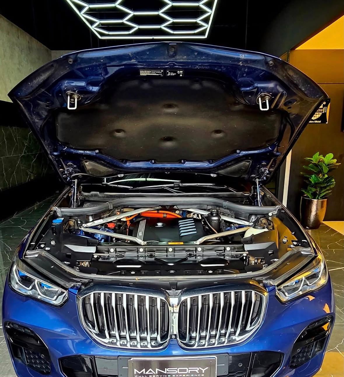Compartimento do motor de um BMW X5 híbrido aberto na oficina